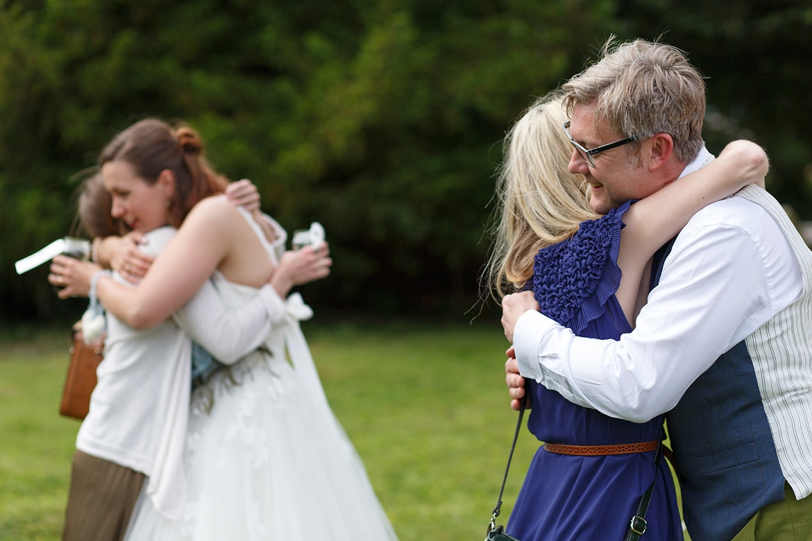 a double hug for the bride and groom