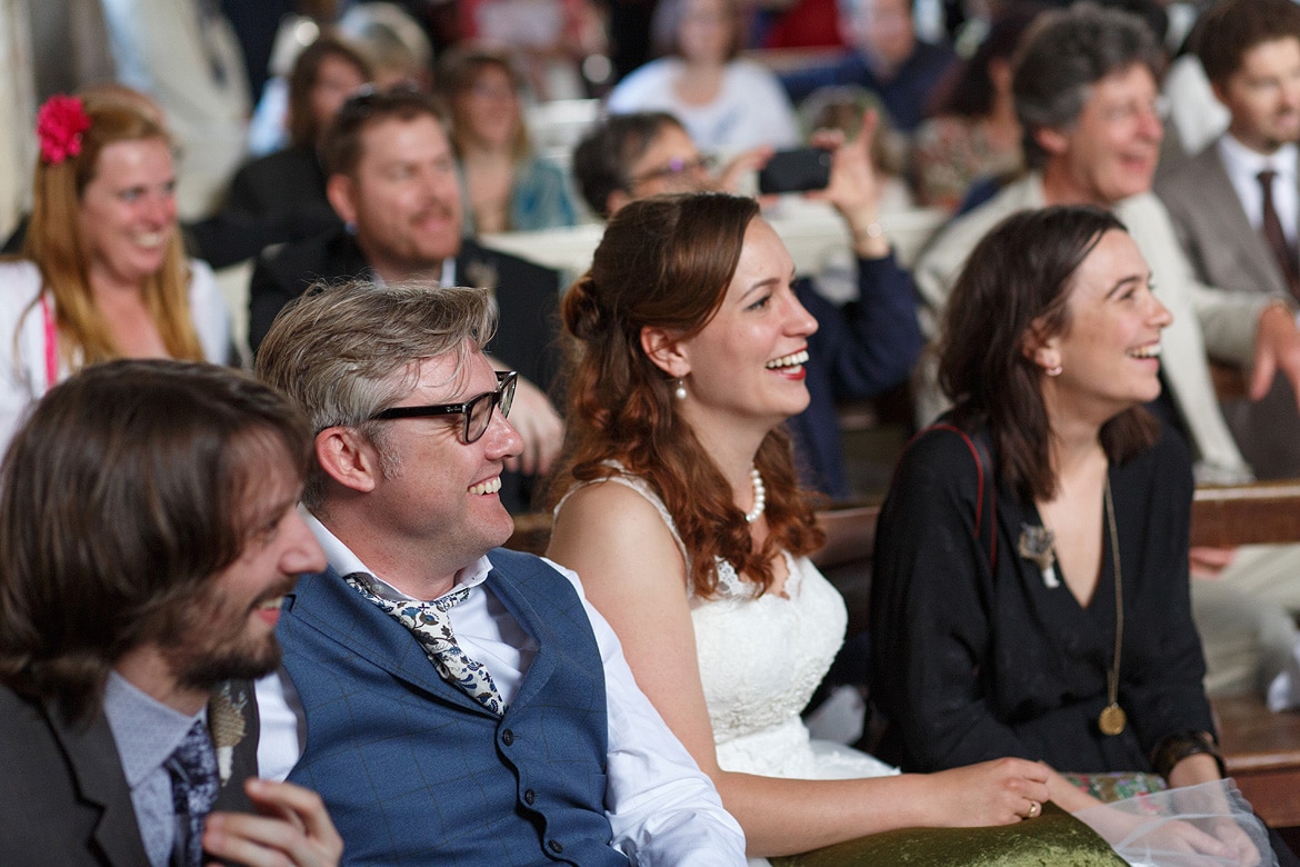 while the bride and groom look on