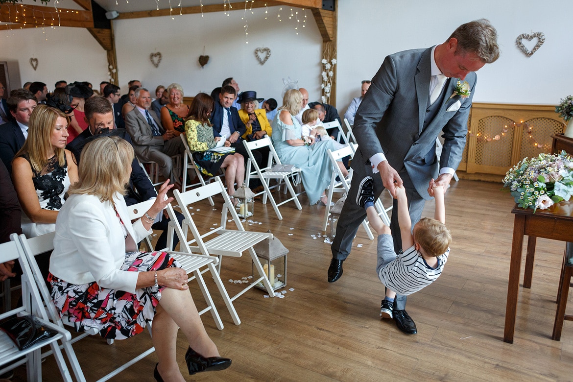 the groom plays with his son before the wedding ceremony