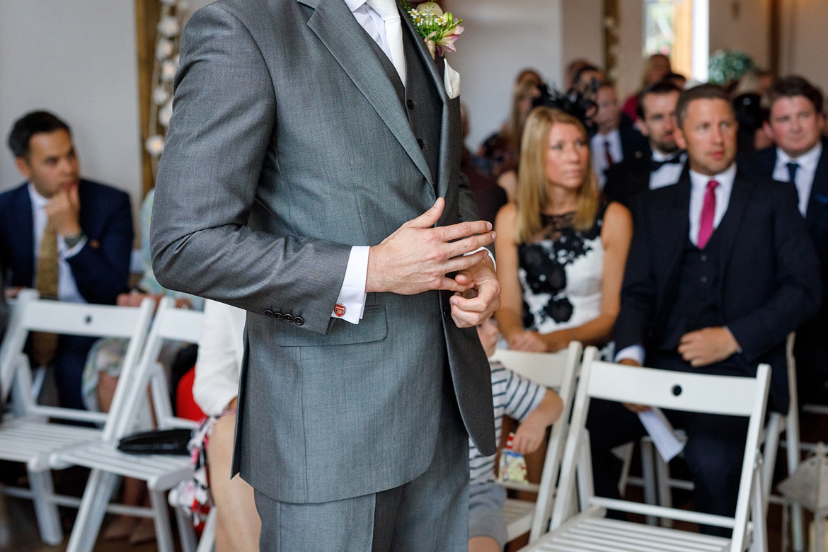 a nervous groom plays with his fingers