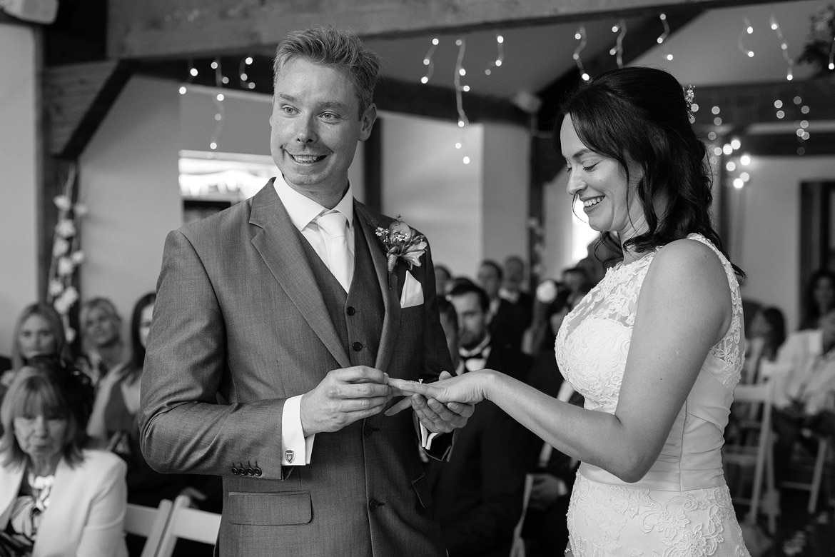 a proud groom places the brides ring