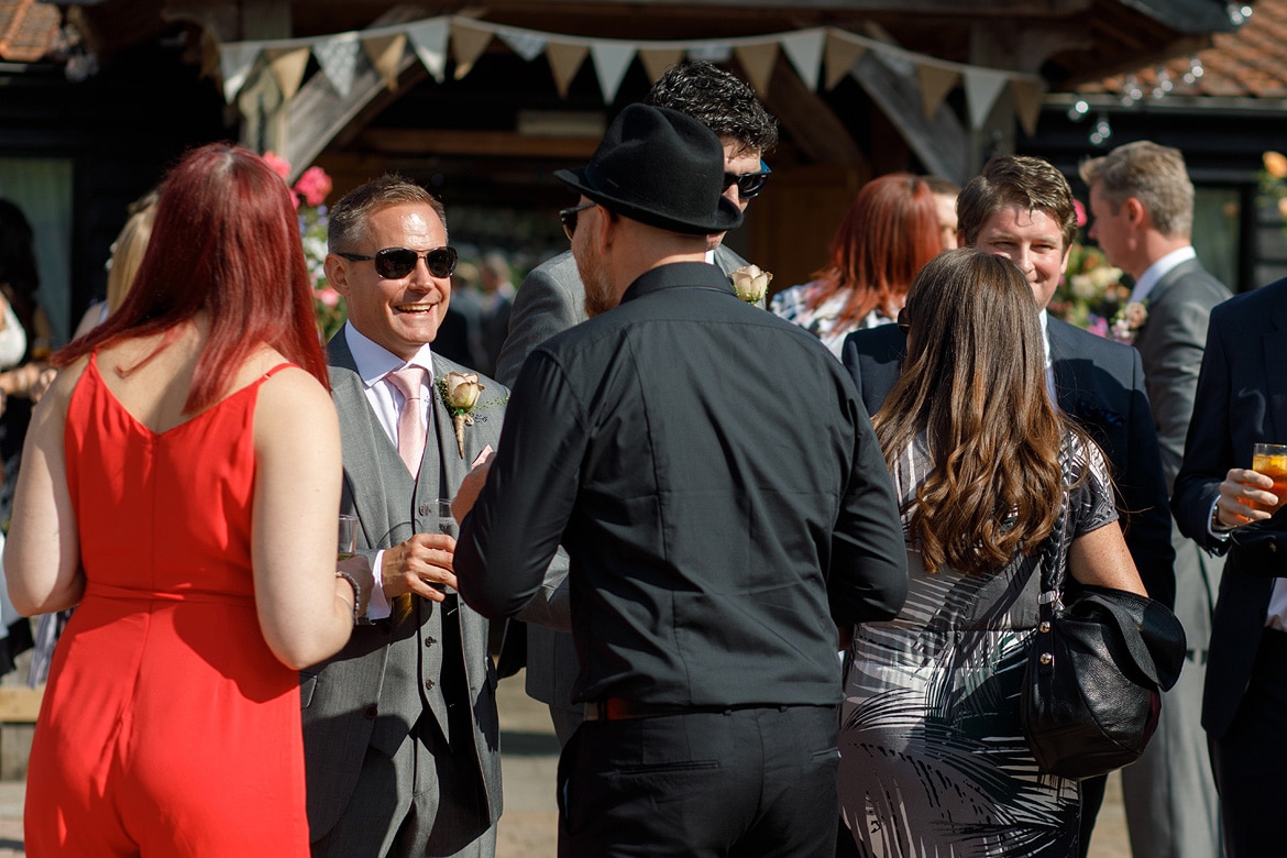 the best man talks to guests outside