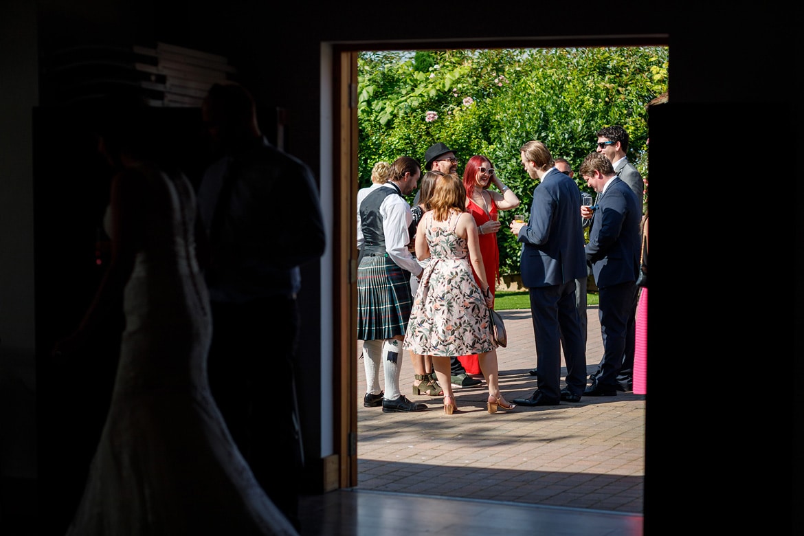 looking out of the barn at a group of wedding guests