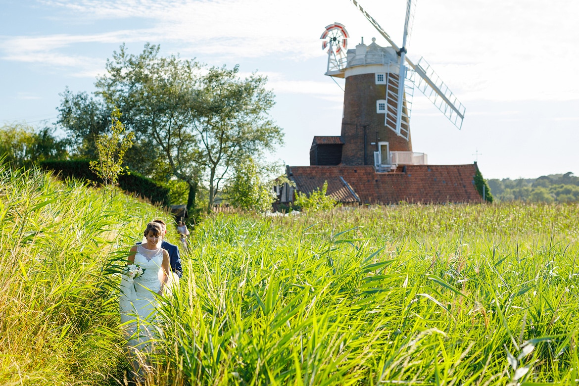 bride and groom walking through the reeds