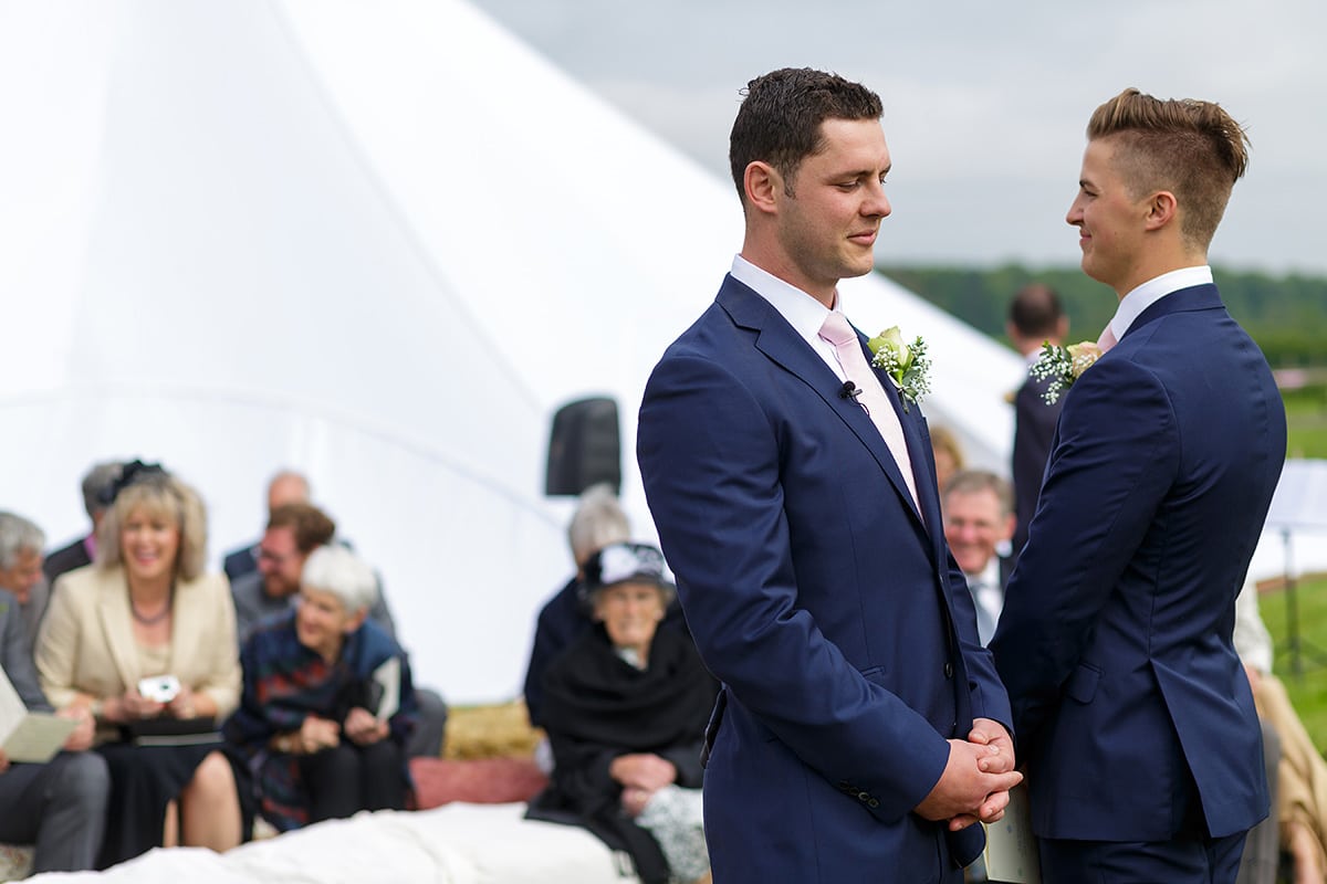 the groom waits at the end of the aisle