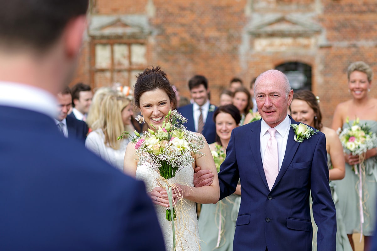 the bride arrives smiling with her father