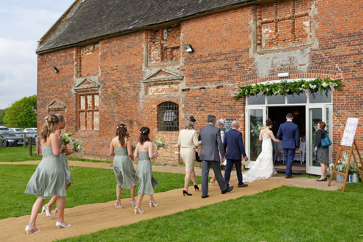 the wedding party enter godwick barn for the legal ceremony