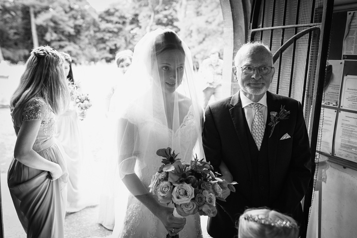 the bride and her father in the porch of bergh apton church