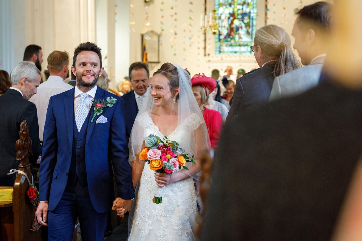 kate and daniel walk back down the aisle at bergh apton church