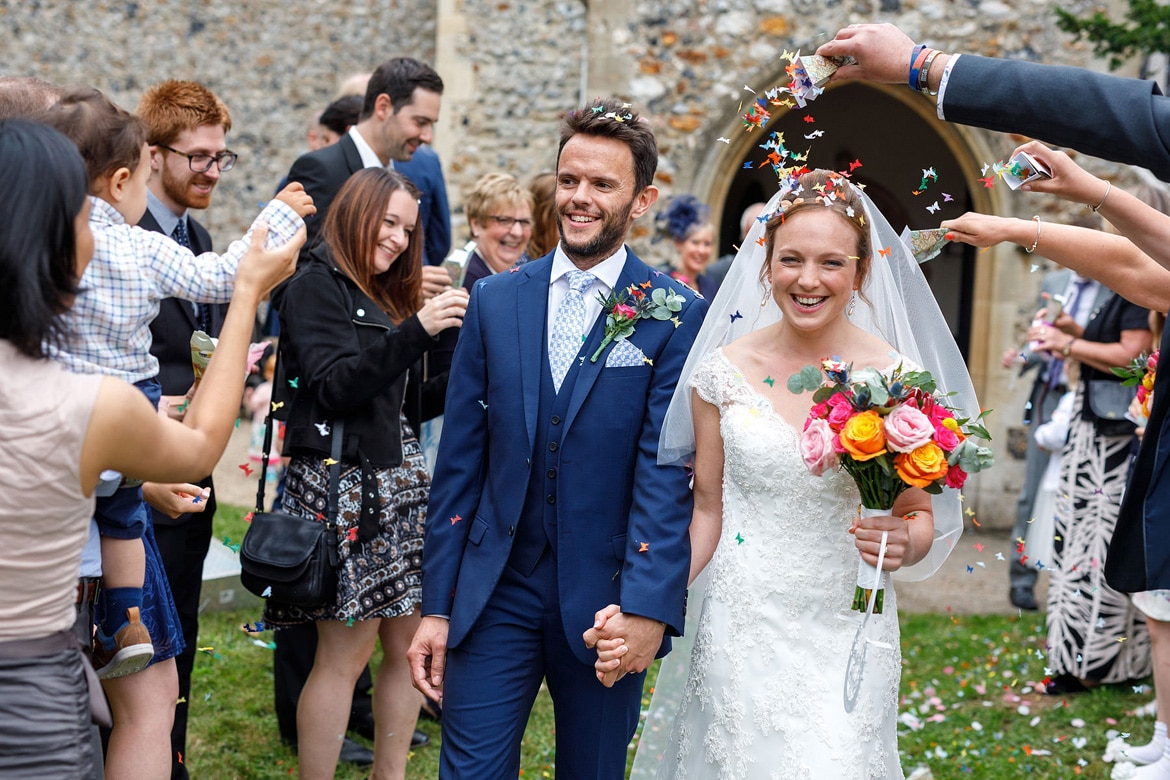 kate and daniel walk through the confetti