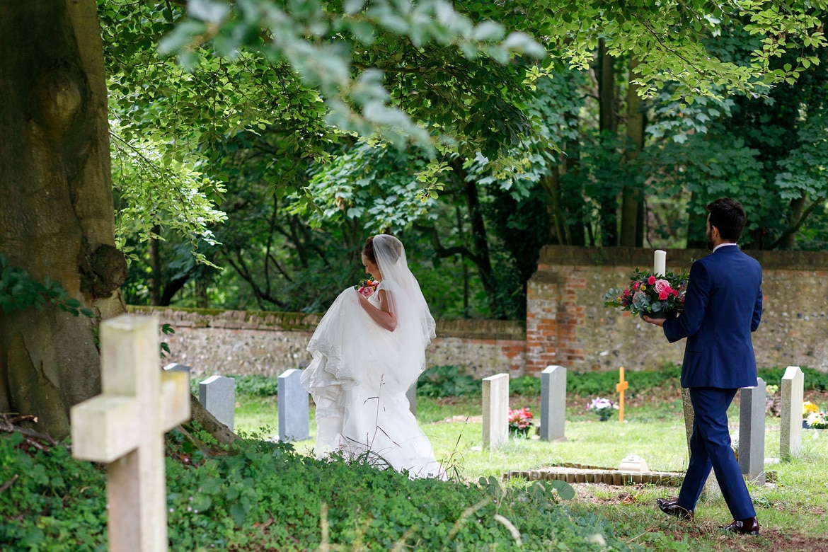 bride and groom walk through the churchyard