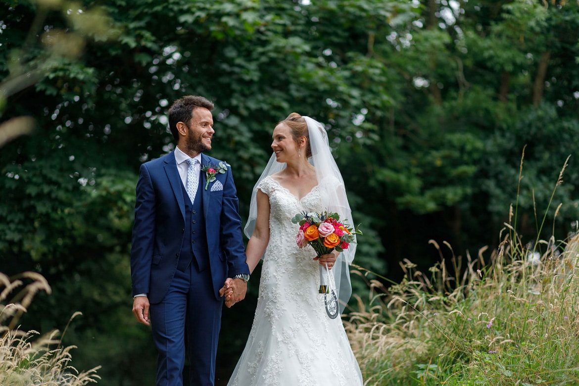 bride and groom walk through bergh apton churchyard