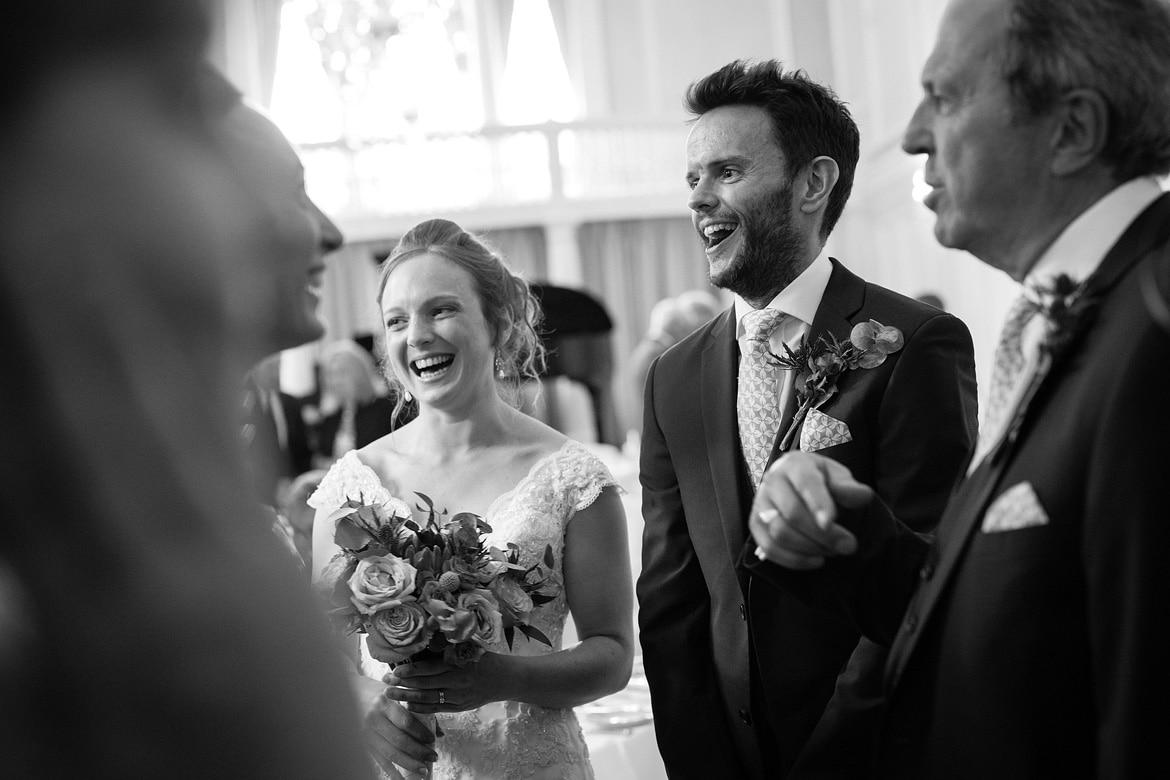 bride and groom laugh in the receiving line