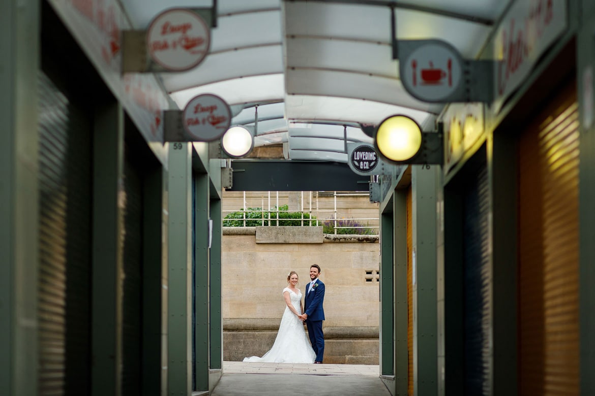 bride and groom viewed from inside norwich market