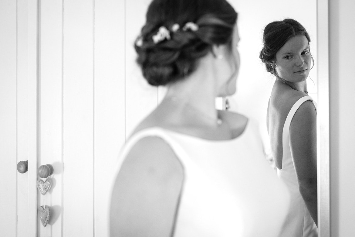 the bride checks herself in the mirror