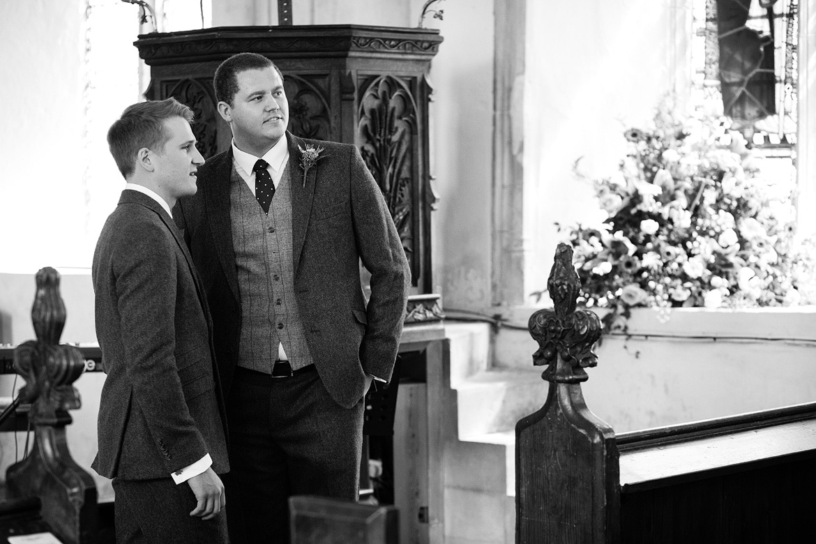 the groom and best man watch their guests arrive