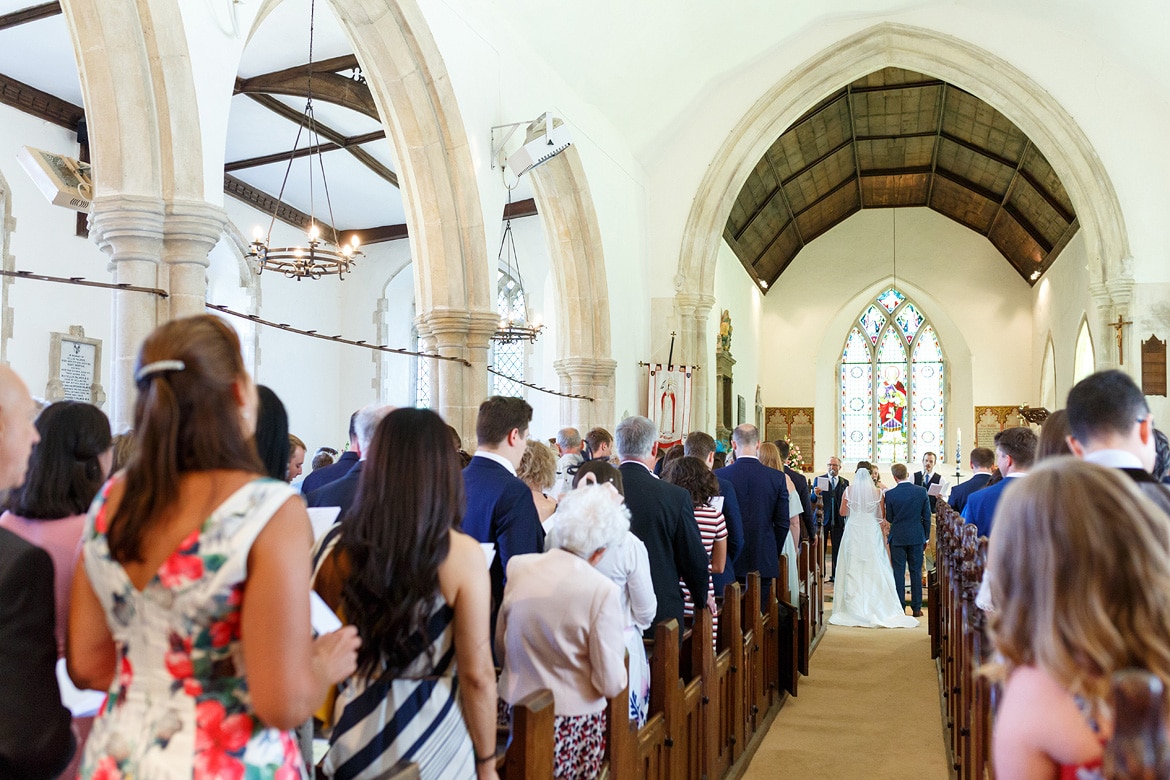a wide view of a wedding at old buckenham church