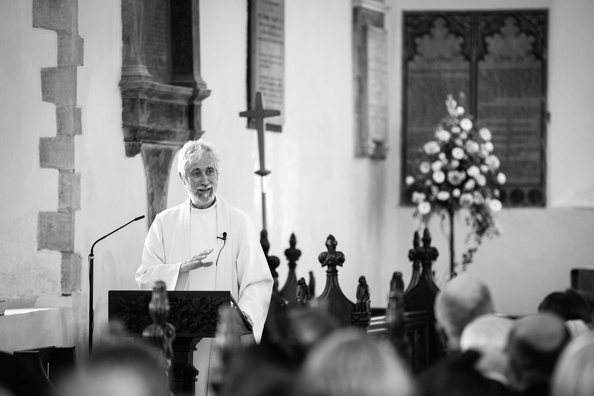 the vicar gives his sermon at an old buckenham church wedding