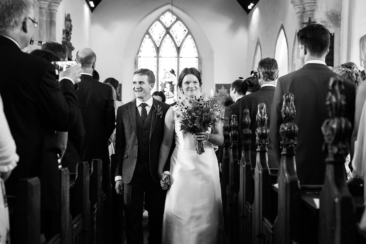 bride and groom walk down the aisle