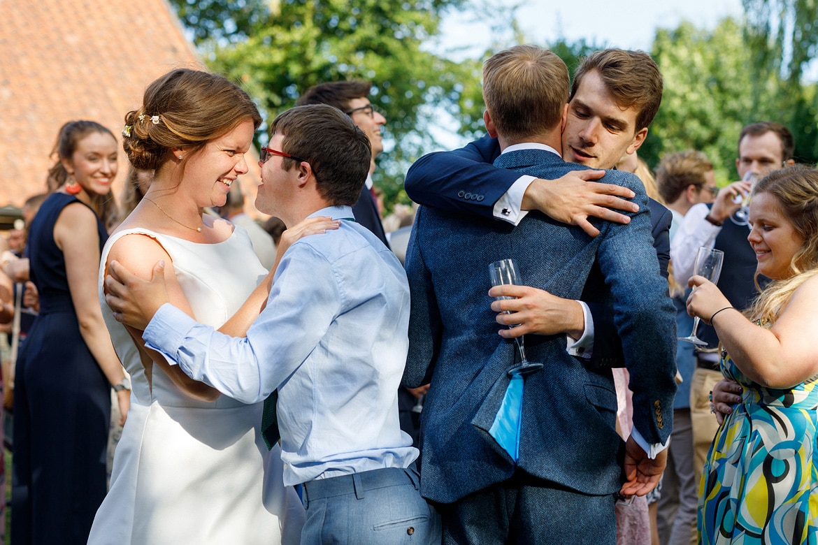 bride and groom are hugged