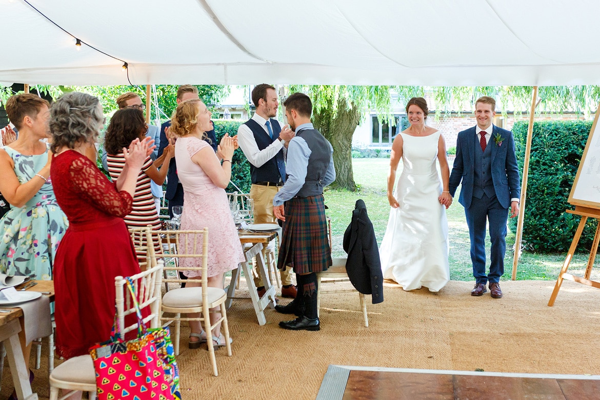 bride and groom enter their wedding breakfast