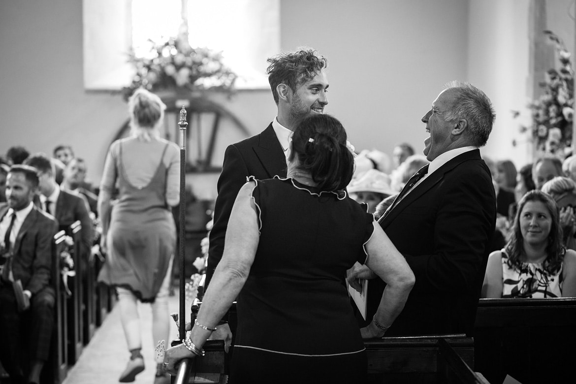 the groom enjoying a moment with guests inside st marys sydenham