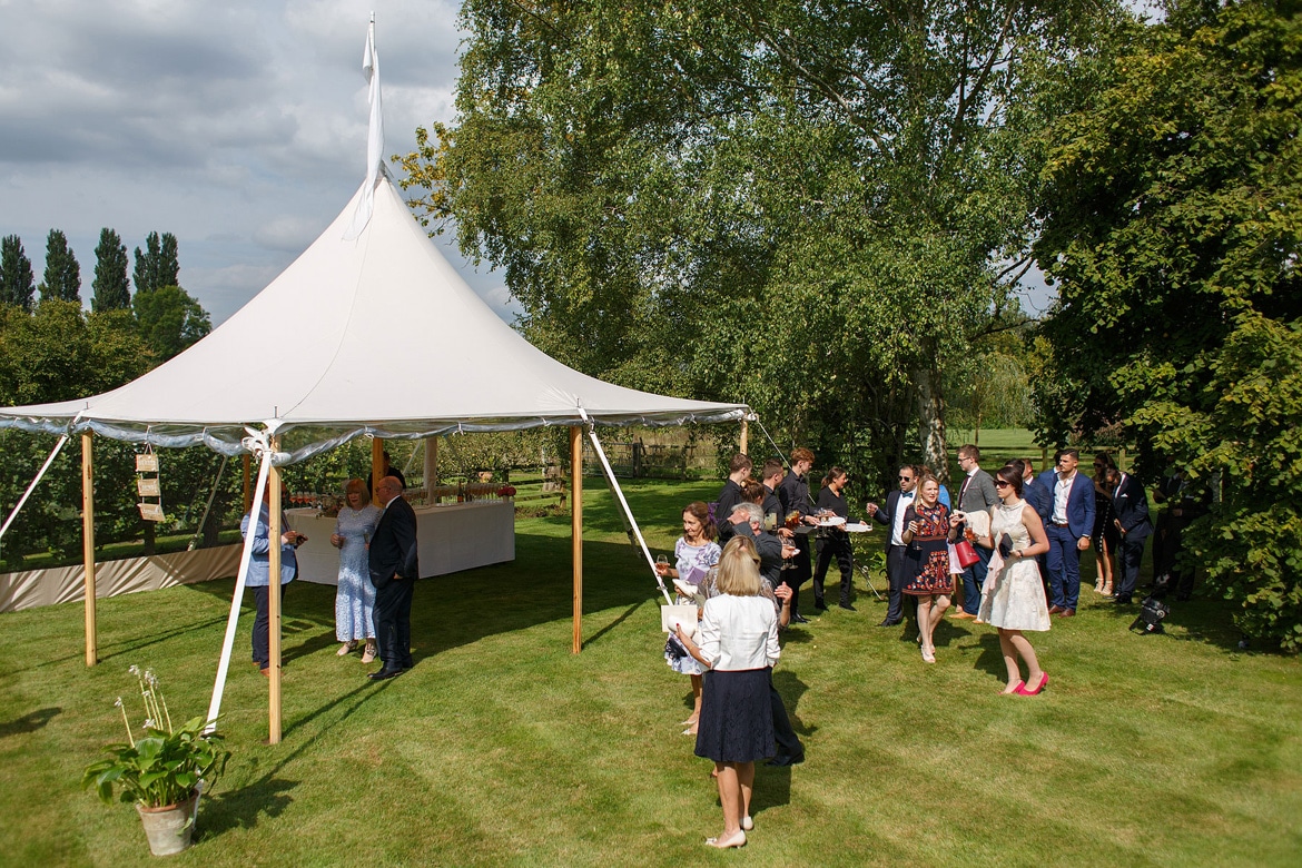 guests arrive for a summer marquee wedding