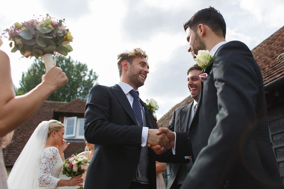 the groom is greeted by his friends