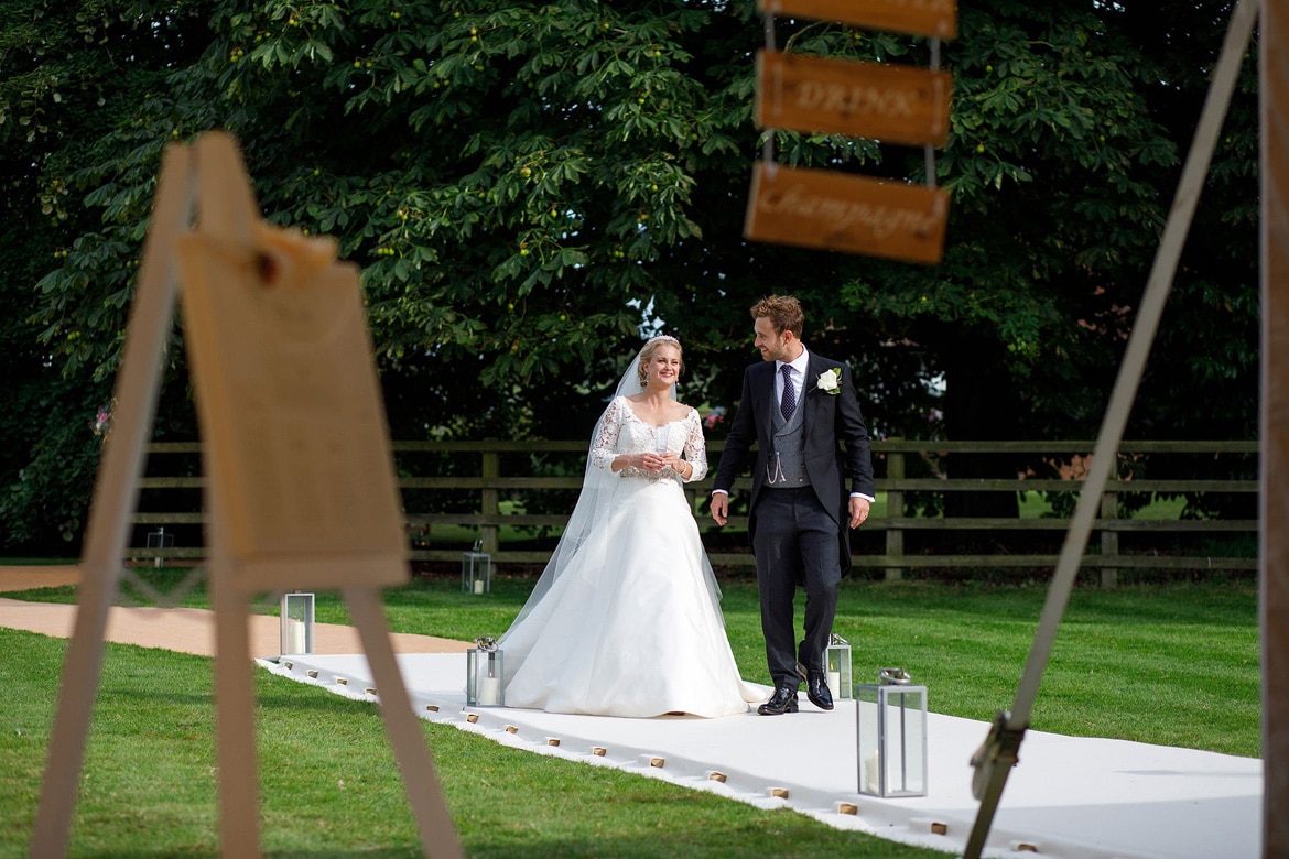 bride and groom walk to the marquee