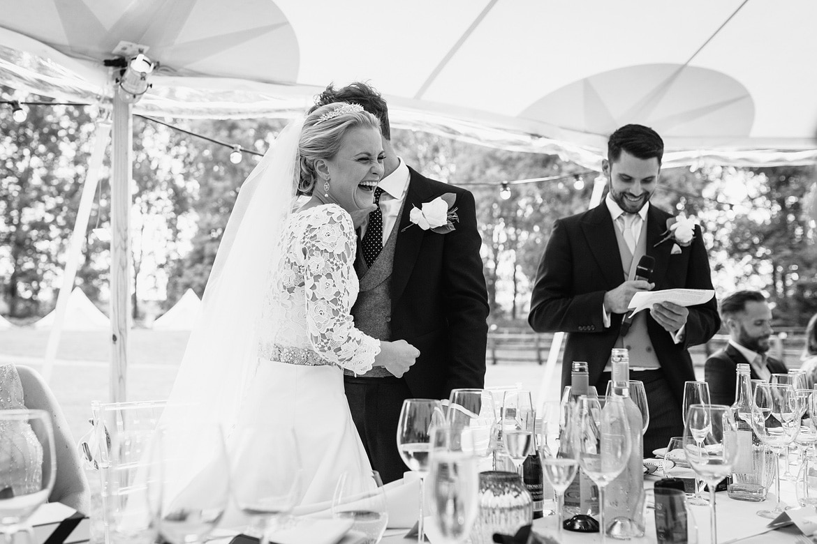 bride and groom laugh during the speeches