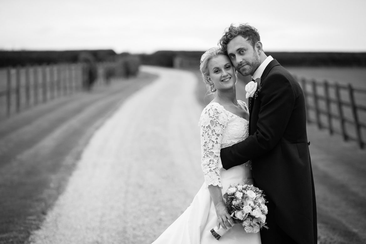 bride and groom pose in the driveway