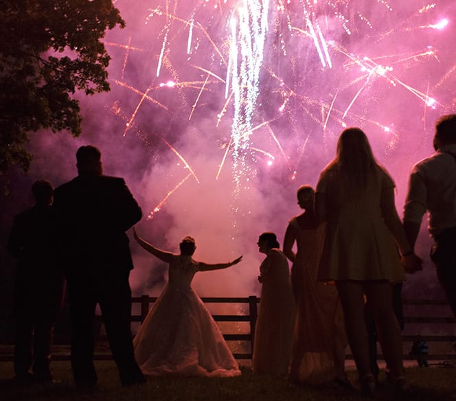 bride dancing in front of wedding fireworks