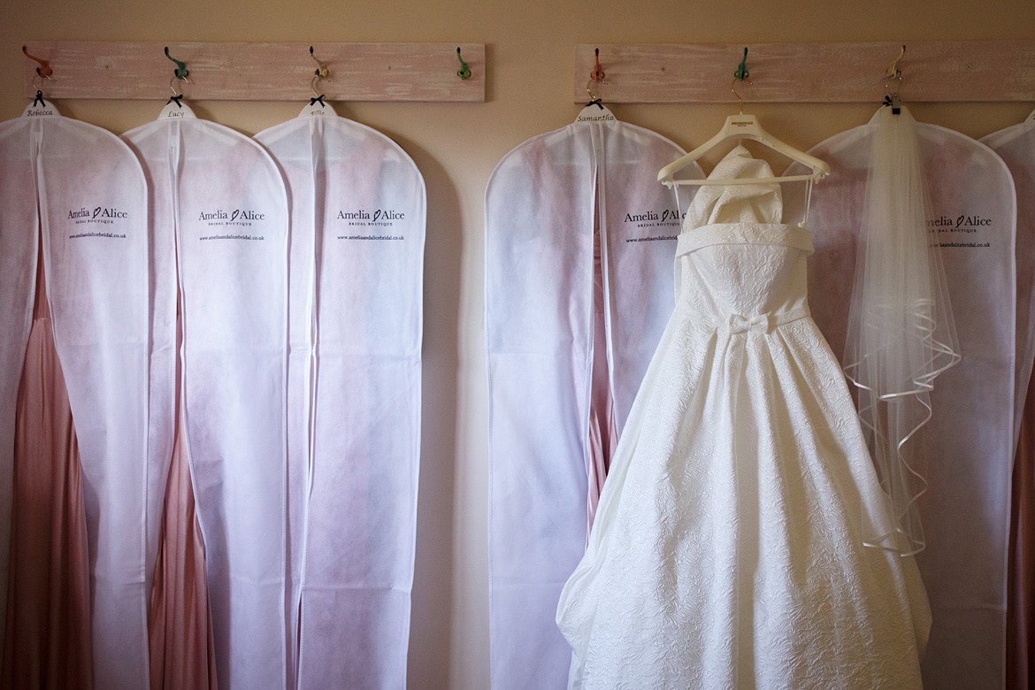 wedding dress hanging with the bridesmaids dresses