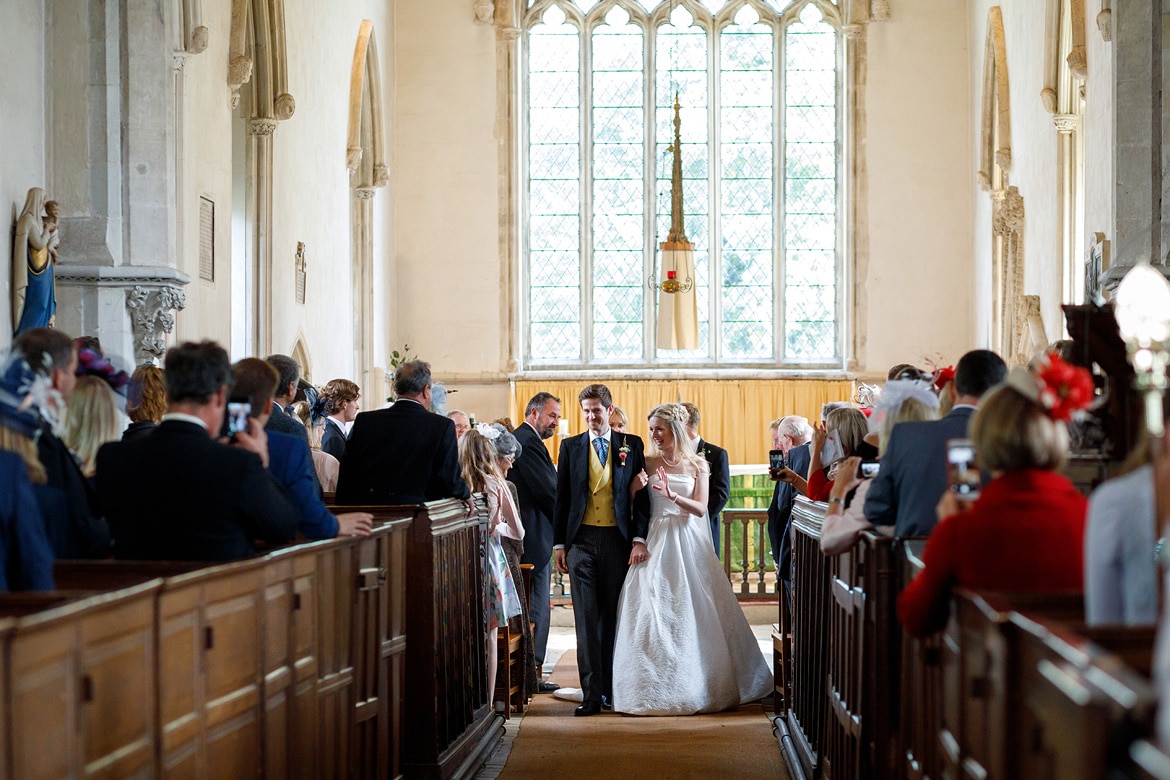bride and groom in the aisle of dennington church