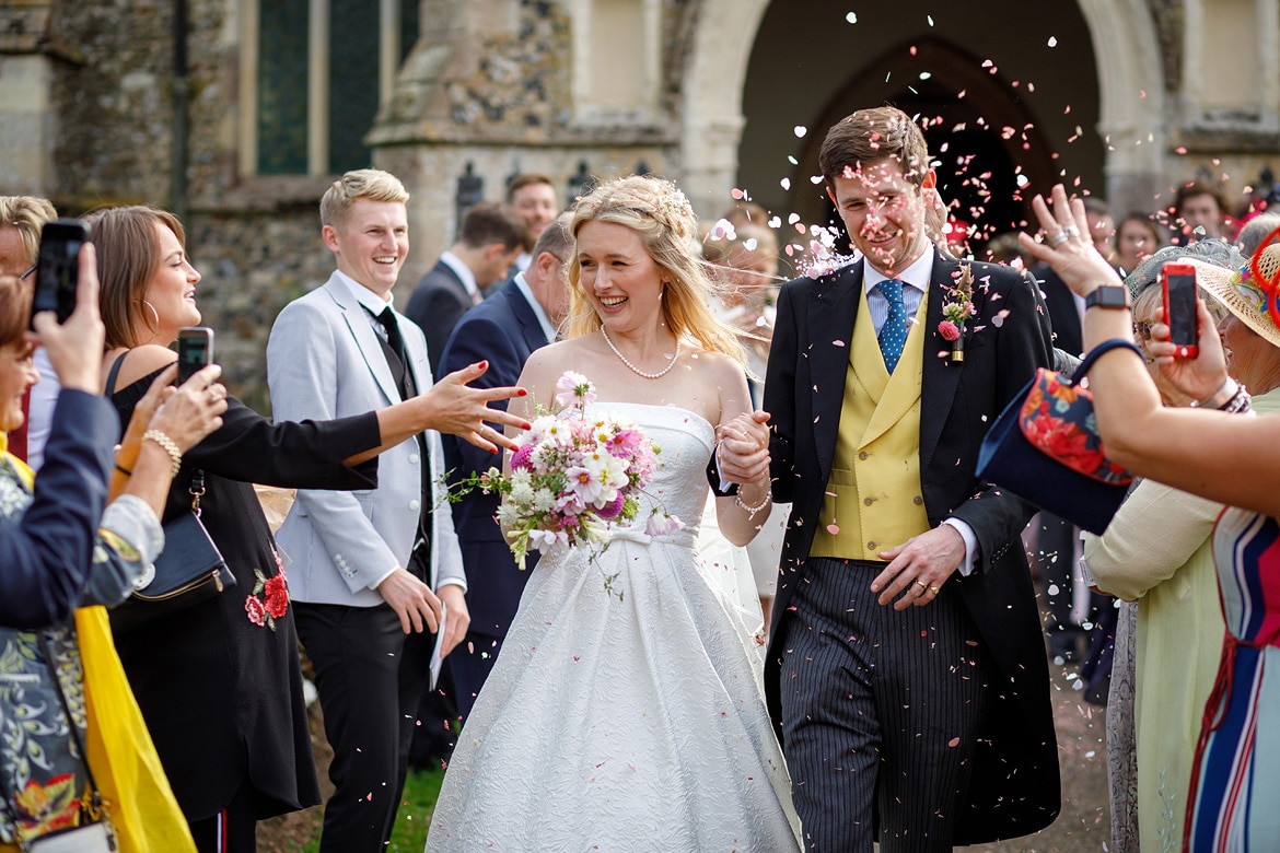 bride and groom walk through the confetti