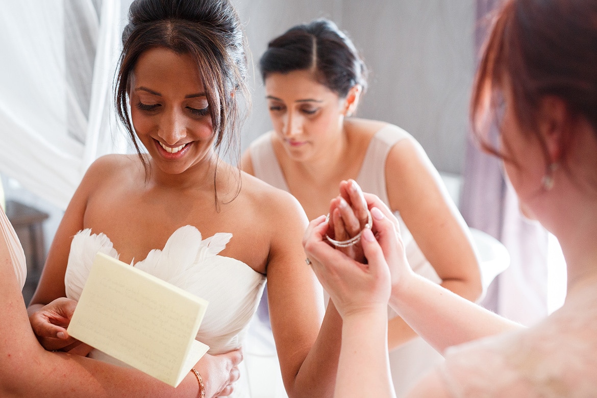 bridesmaids help the bride with her final prepatations