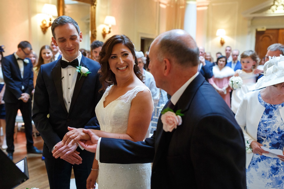 the father of the bride hands over his daughters hand