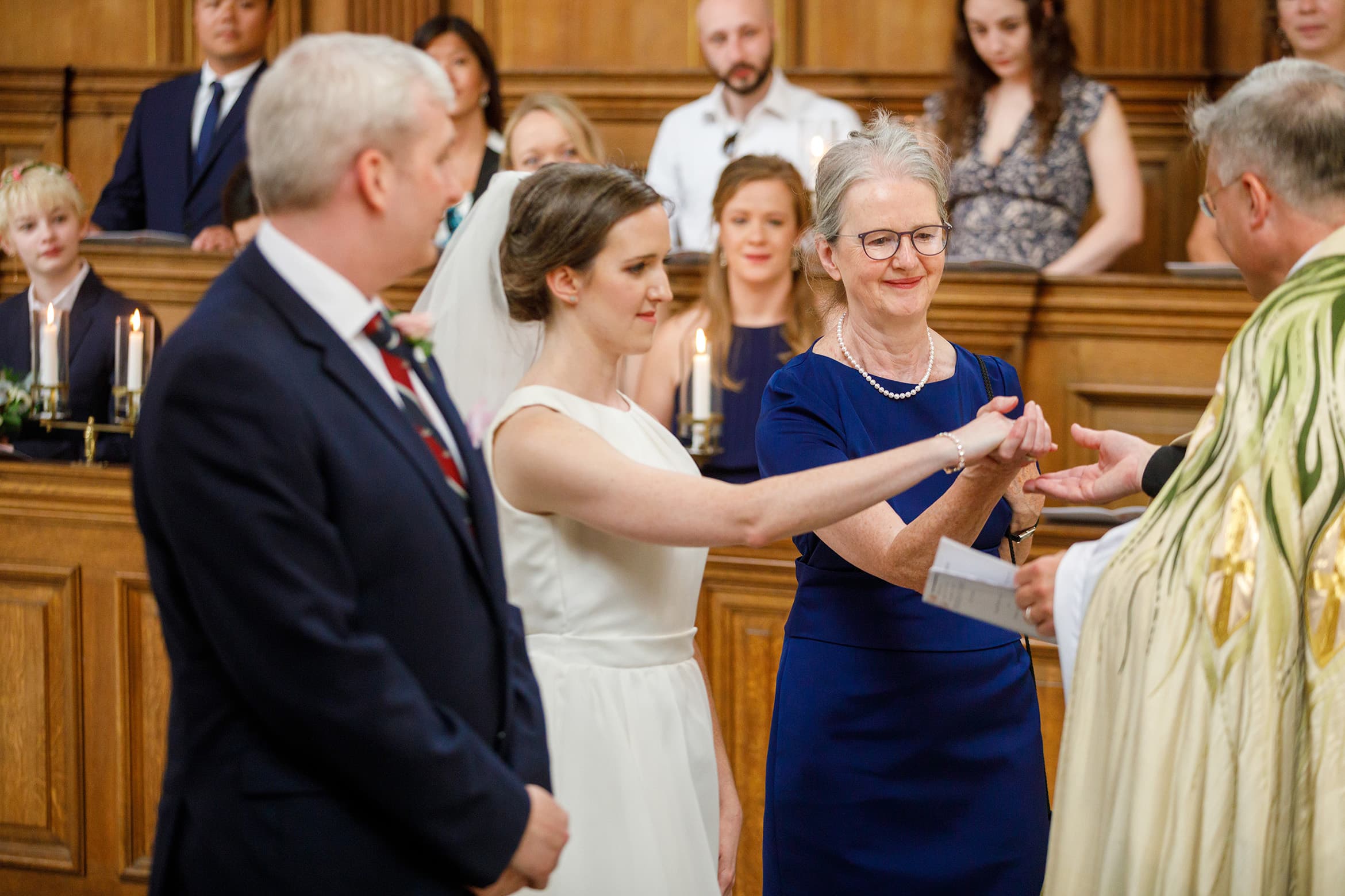 the mother of the bride passes her daughters hand