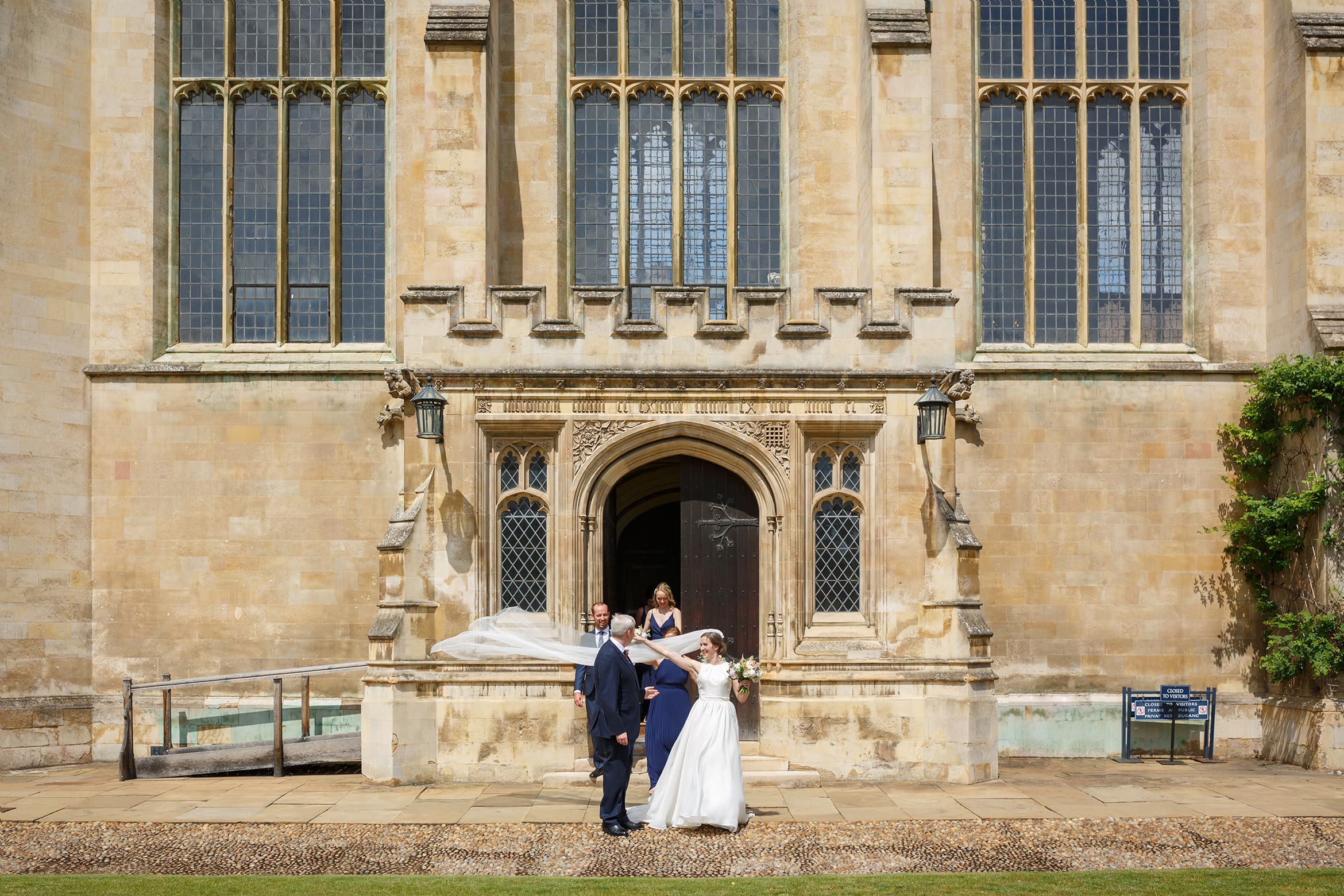 bride and groom outside trinity college cambridge