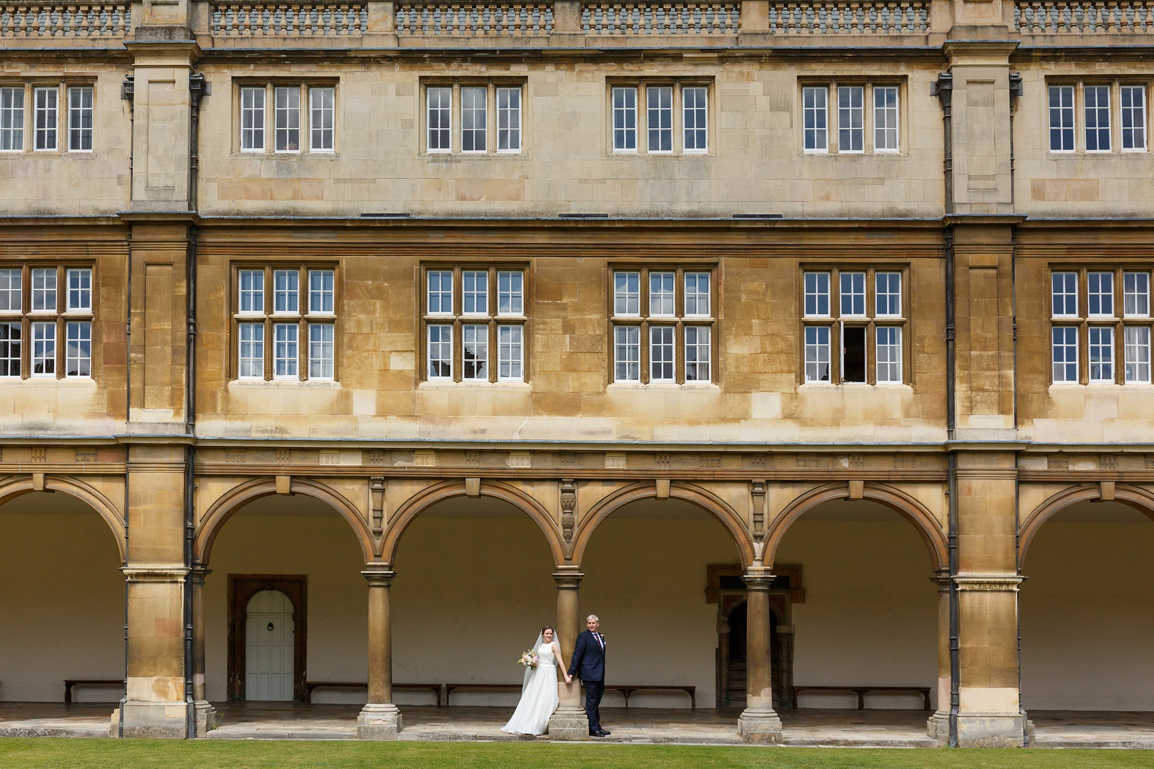 bride and groom pose in the cloisters