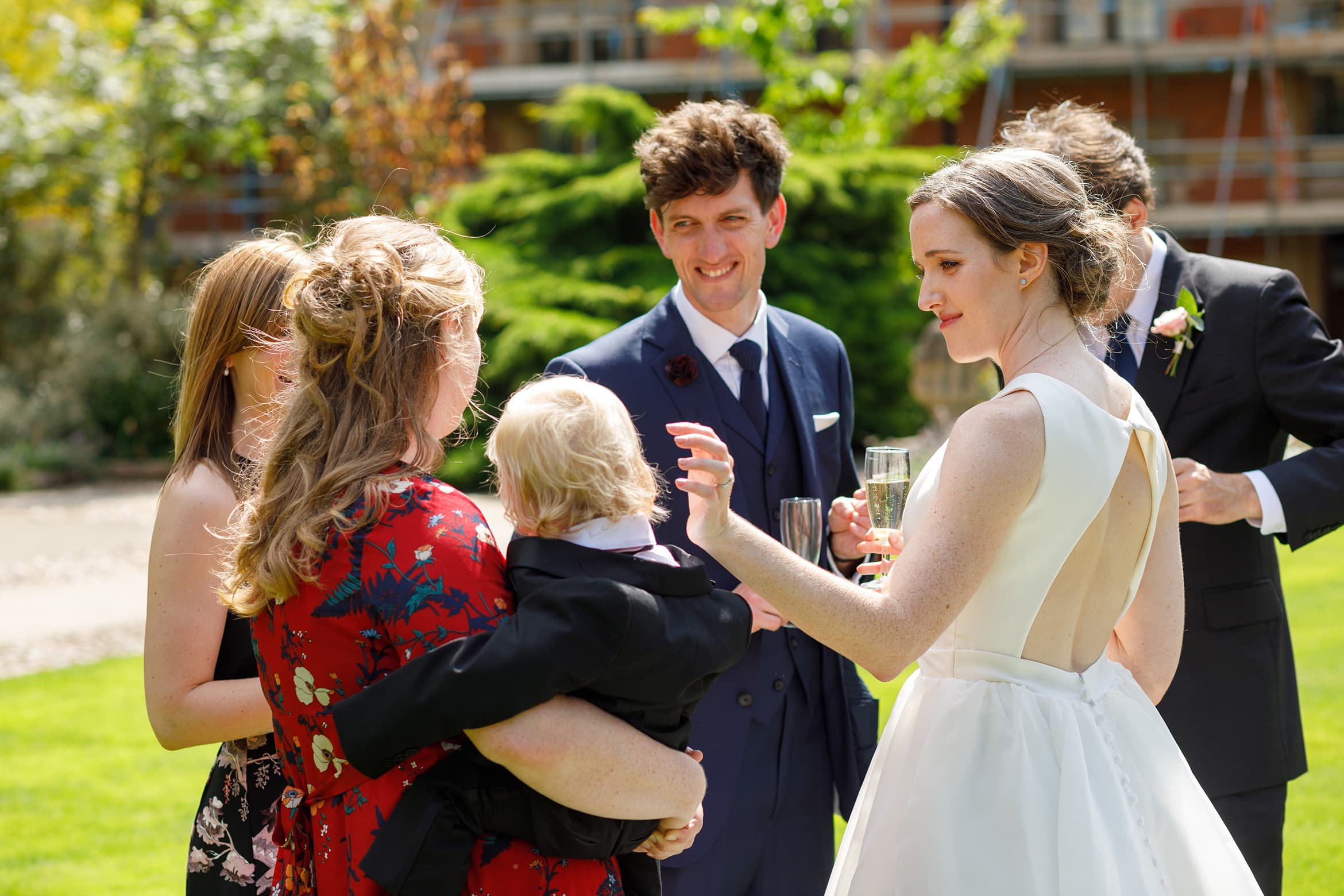 the bride and guests on the lawn at pembroke college