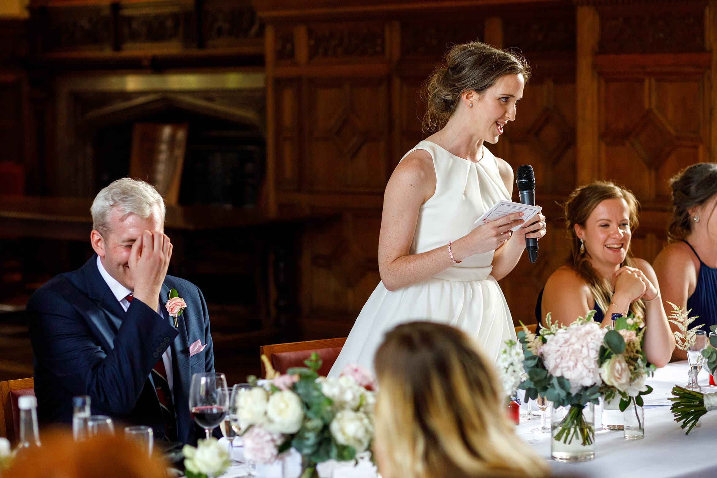 the groom laughs at the brides speech