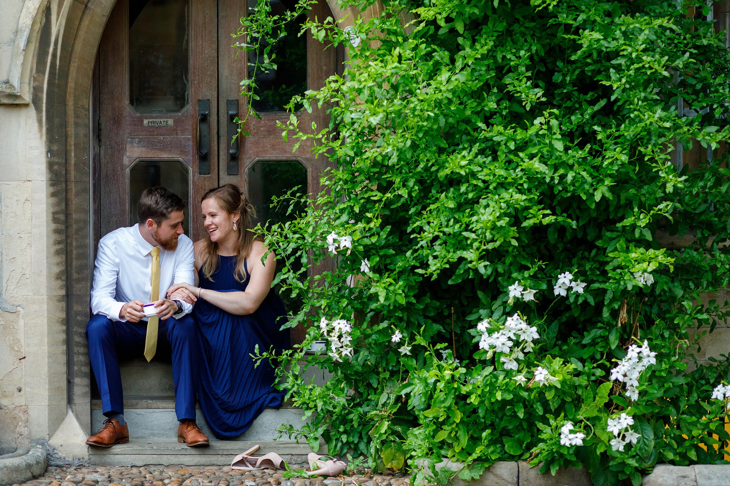 a bridesmaid and her man sit outside