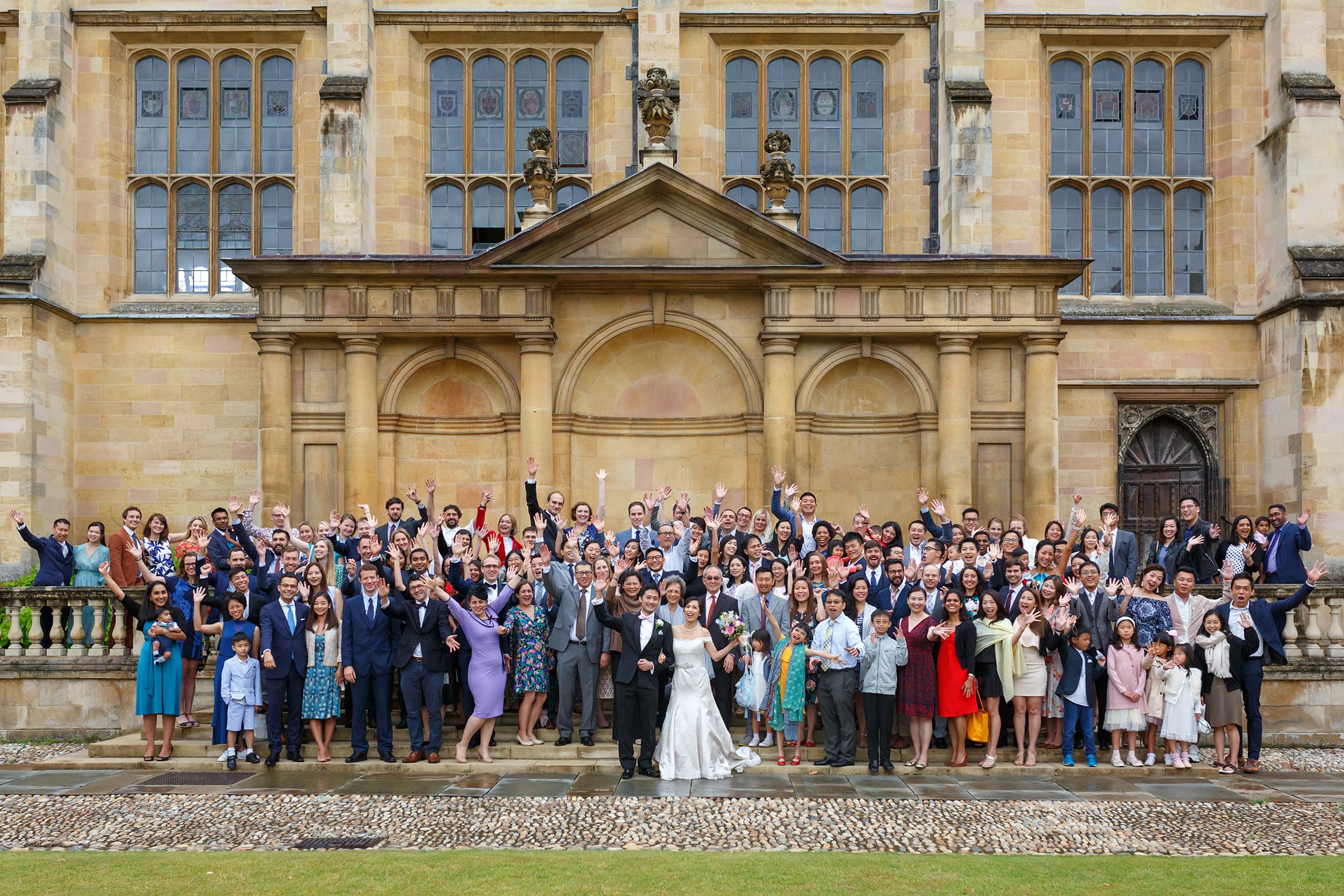 wedding guests on the tribune steps at trinity college cambridge