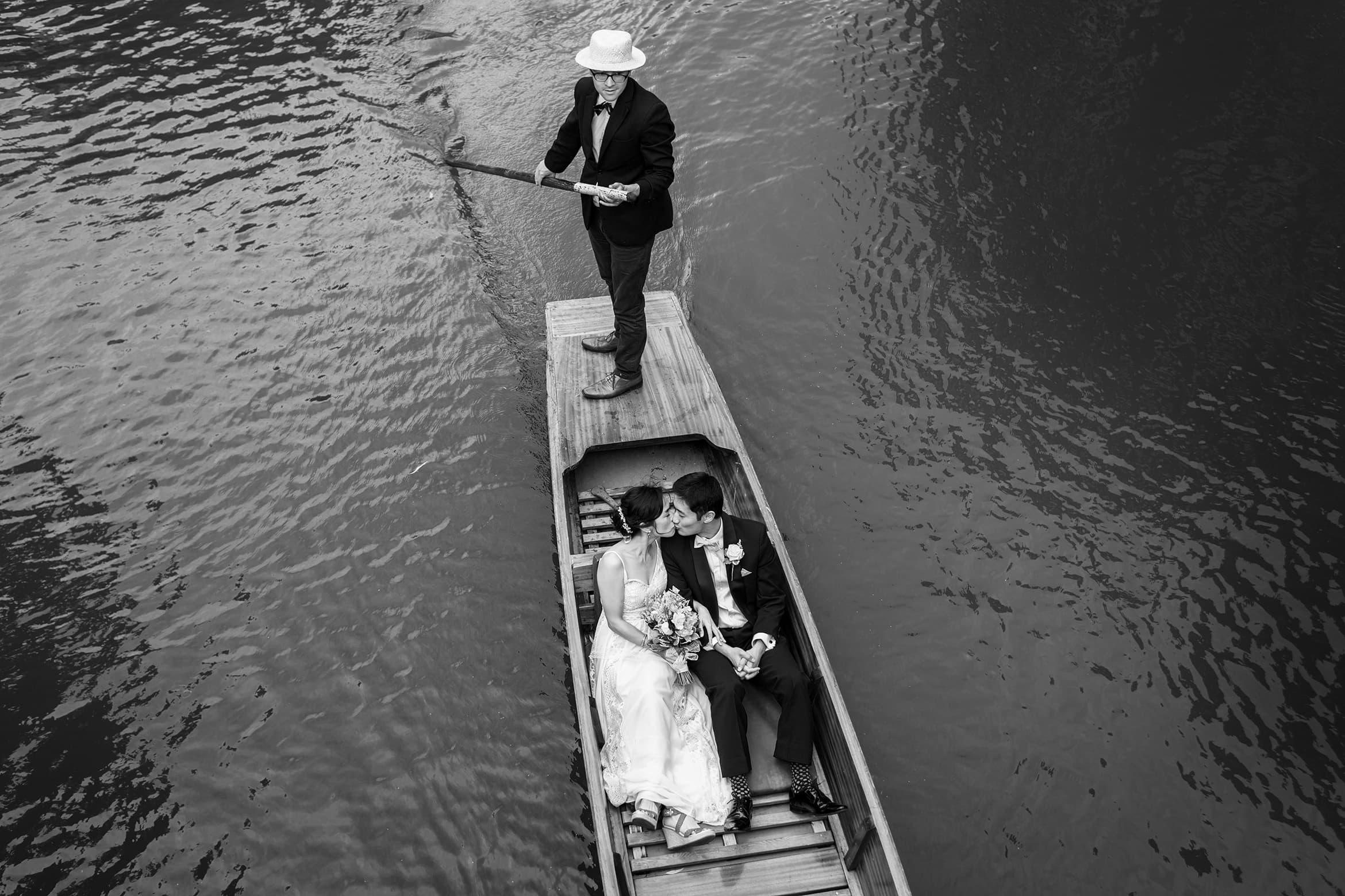 bride and groom kiss in a punt
