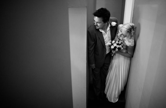 the couple peek into the room before a tuddenham mill wedding ceremony