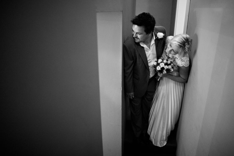 the couple peek into the room before a tuddenham mill wedding ceremony